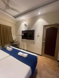 a hotel room with a bed and a flat screen tv at AKG Lodge in Kanchipuram