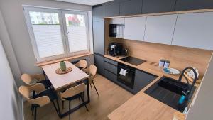 a small kitchen with a small table and chairs at Sowi Kąt CENTRUM in Mikołajki