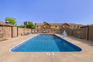 a swimming pool in a yard with a fence at SureStay Plus Hotel by Best Western Kearney in Kearney