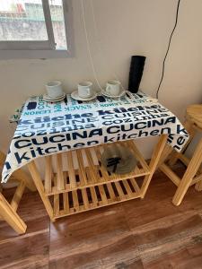 a table with two cups on top of it at Apartamentos Salvador in Termas de Río Hondo