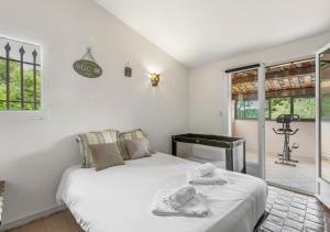 ein weißes Schlafzimmer mit einem Bett und einem Fenster in der Unterkunft Villa provençale calme avec piscine chauffée 6 ch in Le Rouret + 24 Fotos