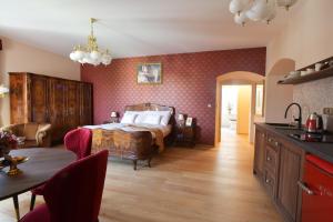 a bedroom with a bed and a table and a kitchen at Zámecké Apartmány Marlene in Česká Kamenice