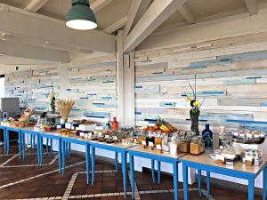 a row of blue tables in a room with food at Mercure Civitavecchia Sunbay Park Hotel in Civitavecchia