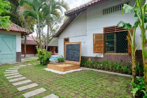 a house with a chalk board in the yard at Entire Heritage Villa Family friendly in the Center of Yogya with Swimming Pool - Up to 9 people in Yogyakarta