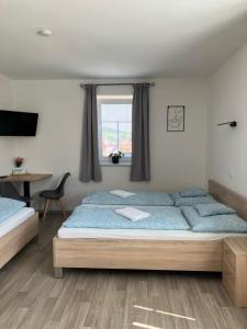 a bedroom with a bed and a desk and a window at Pension Maate in Český Krumlov