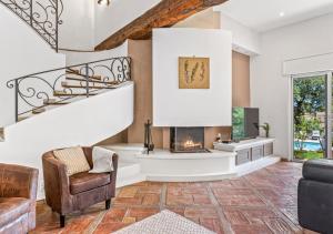 ein Wohnzimmer mit Treppe und Kamin in der Unterkunft Villa provençale calme avec piscine chauffée 6 ch in Le Rouret