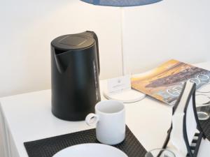 グラードにあるCasa Oleandroの机の上に置かれたコーヒーメーカーとコーヒーマグ