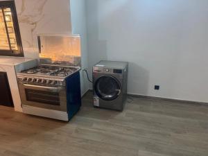 eine Küche mit einem Herd und einer Waschmaschine in der Unterkunft Appartement 2 chambres- salon- Cuisine Résidence Aramys Ngaparou in Ngaparou