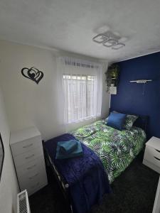 a bedroom with a bed and a window at Woodlands Retreat Holiday Home in Ballantrae