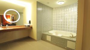 a bathroom with a tub and a sink and a mirror at The Holiday Inn Amarillo West Medical Center by IHG in Amarillo +28 photos