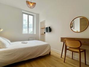 a bedroom with a bed and a desk and a mirror at La Rose des Marais - Renovated & Fully Equipped House in Houesville