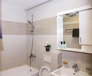 a bathroom with a tub and a toilet and a sink at Adria Mare one bedroom apartment in Tušupi +8 photos