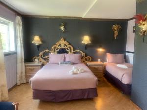 una camera con due letti e pareti rosa e blu di Auberge Restaurant du Monde a Nominingue