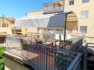 ein Balkon mit Tisch und Stühlen auf einem Gebäude in der Unterkunft Appartamenti Tina Paolini 2 con terrazzo in Castiglione della Pescaia + 11 Fotos