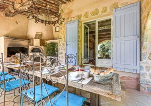 ein großes Esszimmer mit einem Tisch und Stühlen in der Unterkunft Villa provençale calme avec piscine chauffée 6 ch in Le Rouret