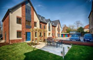 a house with a patio with a table in the yard at Luxury 2 bedroom Flat with Parking in Norwich