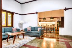 a living room with two blue couches and a table at Entire Heritage Villa Family friendly in the Center of Yogya with Swimming Pool - Up to 9 people in Yogyakarta