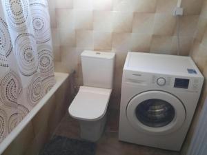 a bathroom with a toilet and a washing machine at Nafpaktos happy town Apartment in port in Nafpaktos +10 photos