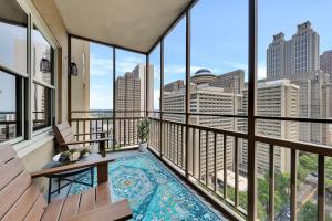 a balcony with a pool and views of the city at "cityscape Retreat" Condo W Balcony King Bed in Atlanta