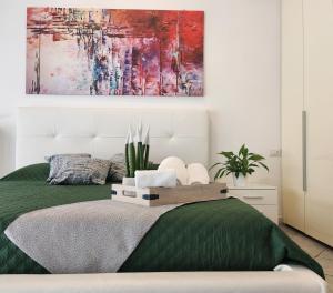 una camera da letto con un letto e un dipinto sul muro di Al civico 10 a Robecchetto con Induno