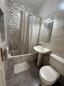 a white bathroom with a toilet and a sink at Camelia - 3 Bedroom Maisonnette with terrace and Seaviews - Bugibba in St Paul's Bay