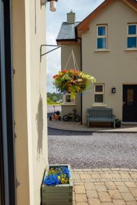 a basket of flowers hanging from a house at An Garaiste in Rosscarbery