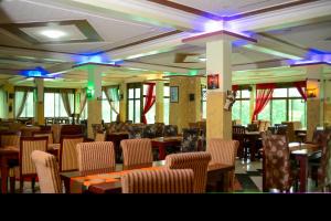 uma sala de jantar com mesas, cadeiras e luzes em Bunyonyi Safaris Resort em Kabale