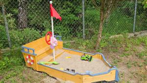 a wooden sandbox with a toy in the sand at Domcio Paluch in Wejdyki