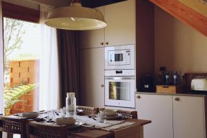 a kitchen with a table with a microwave and a stove at Villaverde Village in Santillana del Mar