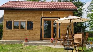a small house with a table and an umbrella at Domcio Paluch in Wejdyki