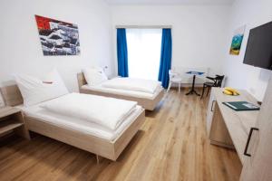 un soggiorno con 2 letti e una scrivania di TPE Arena - Zimmer am Ebersdorfer See a Obergrafendorf
