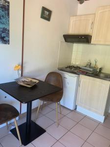 a small kitchen with a black table and a stove at le gite des vignes Studio tout confort 1 chambre dans le vignoble Franche Comte Arbois in Arbois