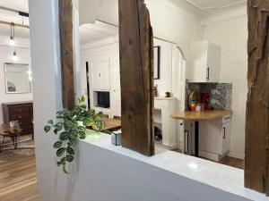 a kitchen with white cabinets and a table with a plant at Aroma Cite Vauban in Briançon