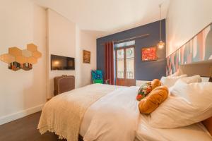 a bedroom with a large white bed with pumpkins on it at Les Seventies - Confort Vintage proche gare in Chambéry