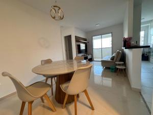 a dining room and living room with a table and chairs at Aruana - Diamante in Aracaju