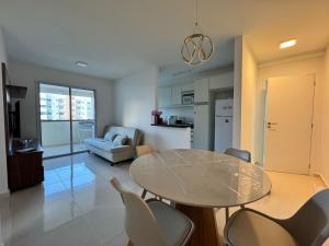 a kitchen and living room with a table and chairs at Aruana - Diamante in Aracaju