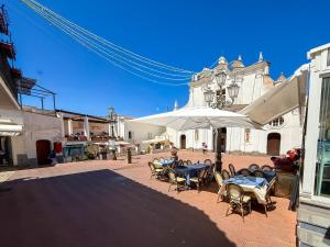 a patio with tables and chairs and an umbrella at Maison MariClà by NDP rent in Anacapri