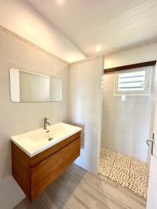 a bathroom with a sink and a shower at Villa " Une Histoire", votre havre de paix à deux pas de la plage in Sainte-Rose