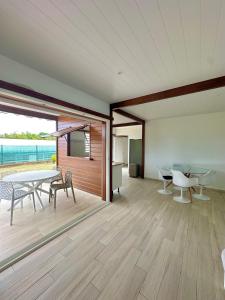 a dining room with a table and chairs and the ocean at Villa " Une Histoire", votre havre de paix à deux pas de la plage in Sainte-Rose