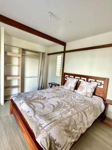 a bedroom with a large bed in a room at Villa " Une Histoire", votre havre de paix à deux pas de la plage in Sainte-Rose +10 photos