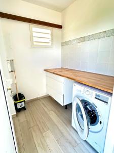 a laundry room with a washer and dryer at Villa " Une Histoire", votre havre de paix à deux pas de la plage in Sainte-Rose
