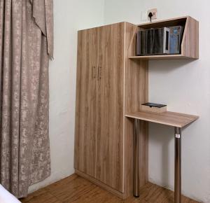 a wooden cabinet in a room with a table at The Queens Hotel in Kimberley