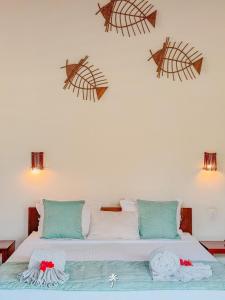 a bedroom with a bed with three pieces of art on the wall at Villa Guaiuba linda casa com piscina e vista por mar ! in Icaraí