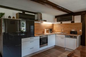 a kitchen with white cabinets and black appliances at Hof Hummersen in Lügde