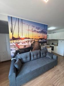 a living room with a couch and a painting of a harbor at Żeglarska przystań in Giżycko
