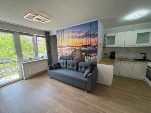 a living room with a couch and a kitchen at Żeglarska przystań in Giżycko