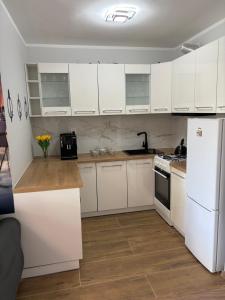 a kitchen with white cabinets and a white refrigerator at Żeglarska przystań in Giżycko +30 photos