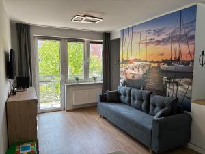 a living room with a couch and a painting on the wall at Żeglarska przystań in Giżycko