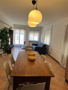 a living room with a wooden table and chairs at Appartamento Sirio in Asiago +4 photos