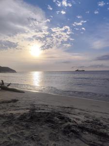 a person laying on the beach near the ocean at Habitación Vacacional in Santa Marta +6 photos